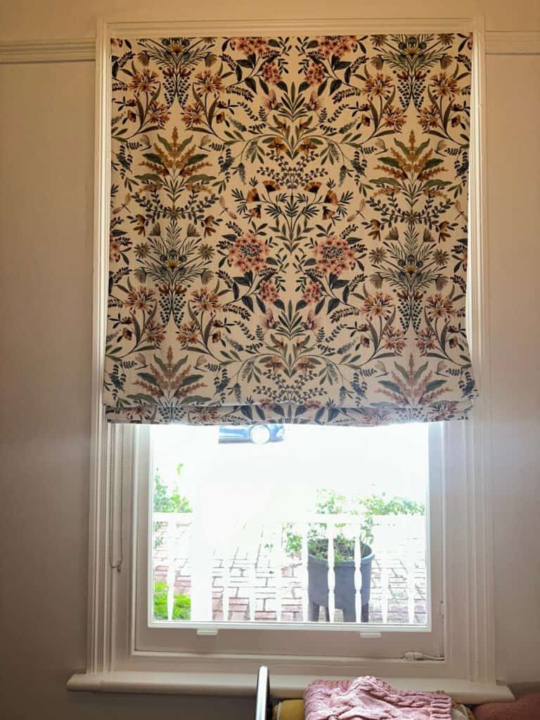 Soft Roman blind lowered flat above a bed in a North Perth heritage home