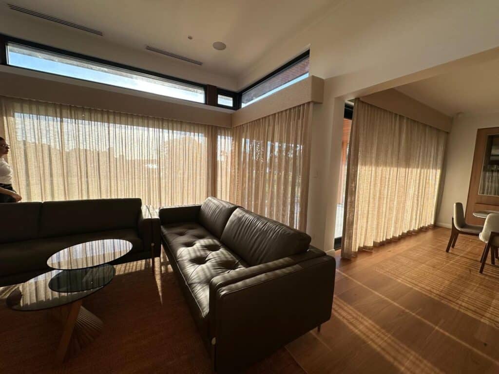 Fabric box pelmet wrapped to match the wall tone above sheer curtains in a Perth living room